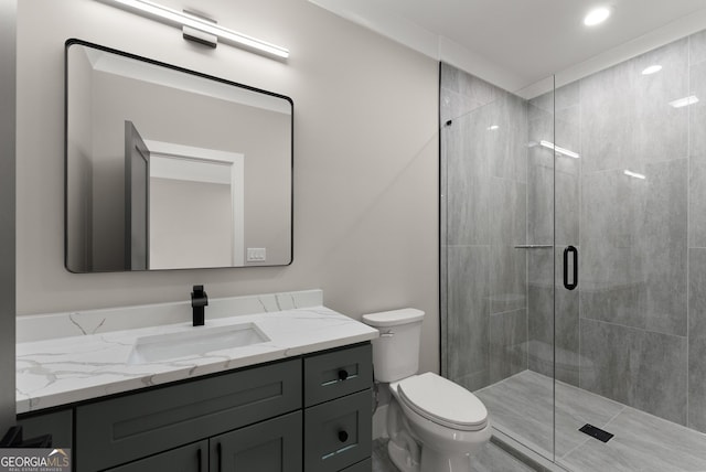 full bathroom featuring toilet, vanity, and a shower stall