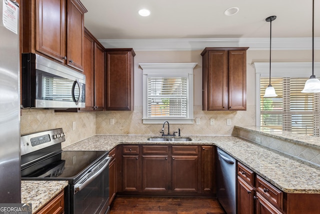 kitchen featuring a sink, dark wood finished floors, crown molding, stainless steel appliances, and backsplash