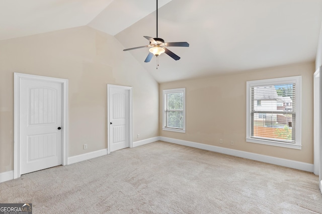 interior space with baseboards, light carpet, multiple closets, ceiling fan, and high vaulted ceiling