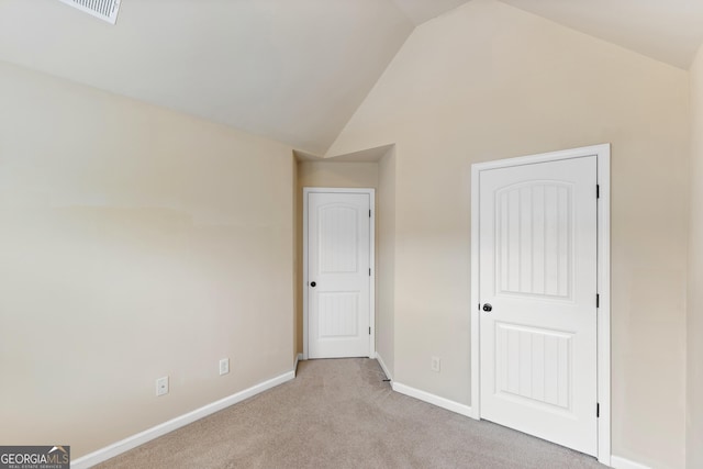 unfurnished bedroom with high vaulted ceiling, visible vents, baseboards, and carpet floors