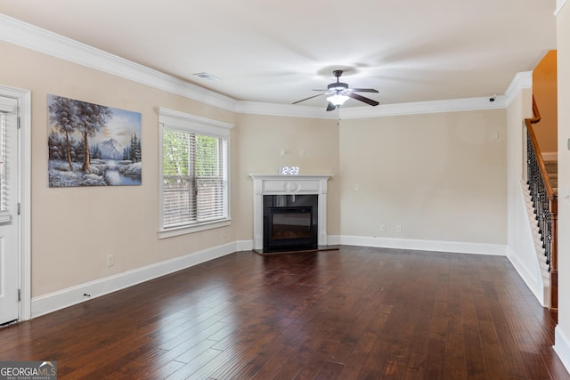unfurnished living room featuring a glass covered fireplace, dark wood-style flooring, stairs, visible vents, and ceiling fan