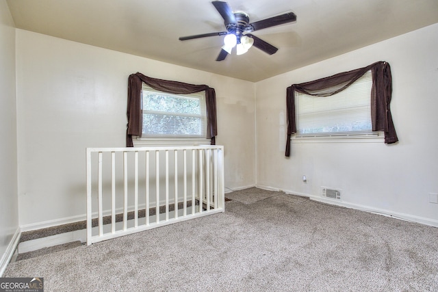 unfurnished bedroom featuring carpet flooring, baseboards, ceiling fan, and visible vents