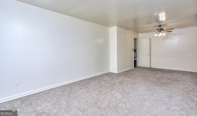 carpeted spare room featuring baseboards and ceiling fan