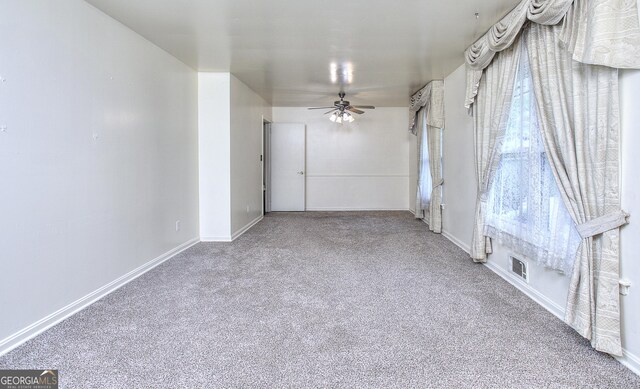 spare room with baseboards, carpet flooring, visible vents, and a ceiling fan