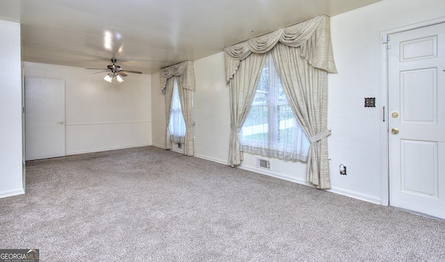 interior space featuring baseboards, ceiling fan, and visible vents