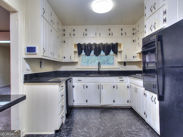 kitchen featuring marble finish floor, dark countertops, black appliances, and a sink