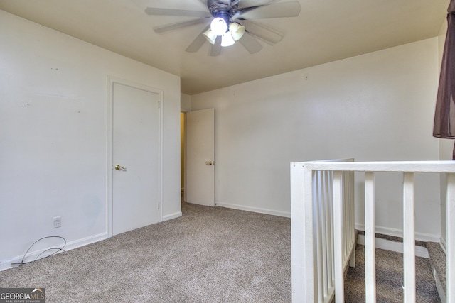 carpeted spare room with baseboards and ceiling fan