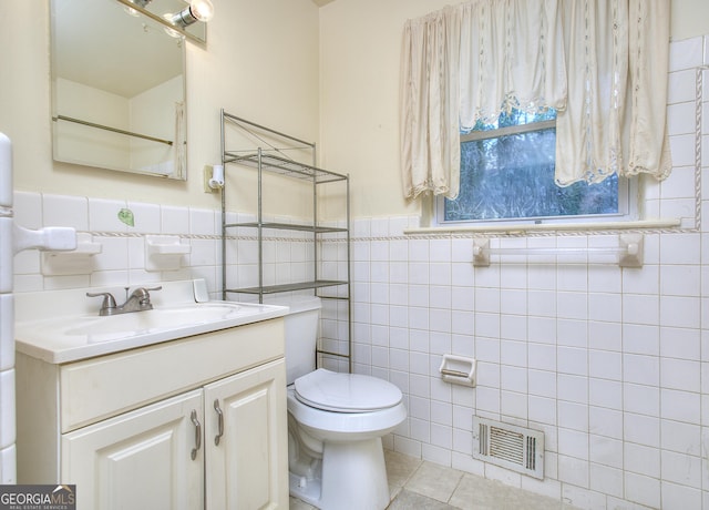 bathroom with tile patterned flooring, vanity, tile walls, toilet, and visible vents