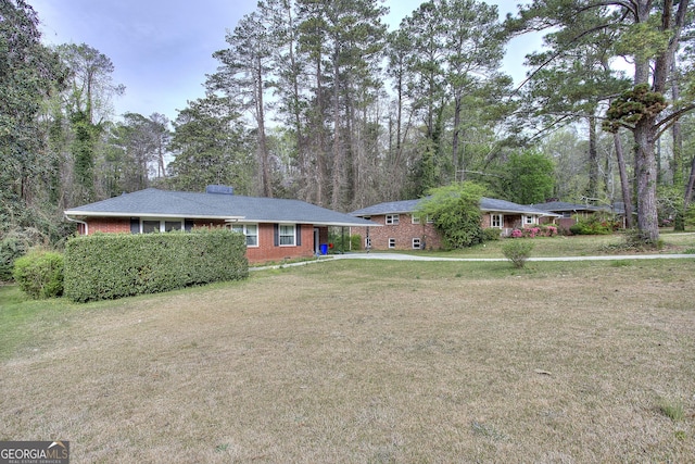 ranch-style home with a front yard and brick siding