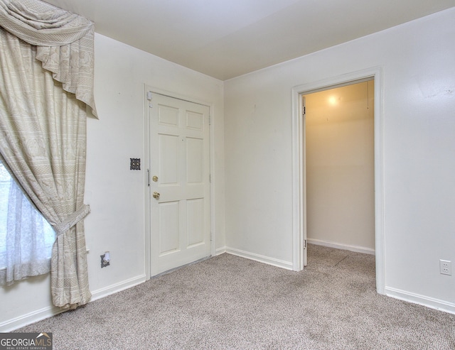 carpeted entryway featuring baseboards