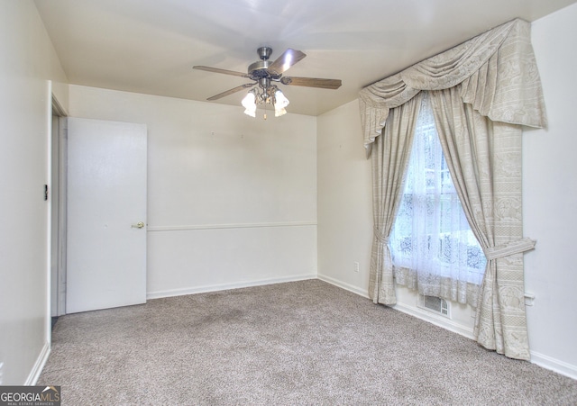 empty room with baseboards, visible vents, carpet floors, and a ceiling fan