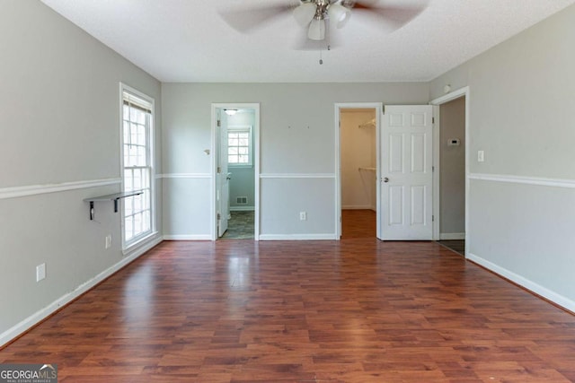 empty room with baseboards, visible vents, wood finished floors, and a ceiling fan