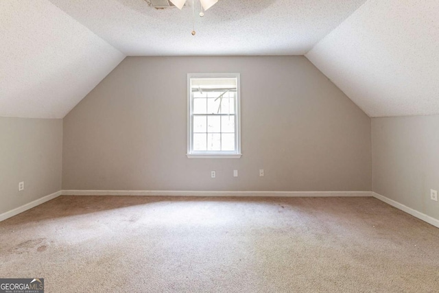 bonus room with baseboards, carpet floors, and a textured ceiling