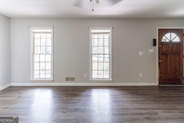 entrance foyer with wood finished floors, a textured ceiling, ceiling fan, and visible vents