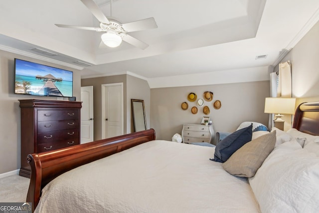 bedroom featuring ornamental molding, a tray ceiling, light colored carpet, and ceiling fan