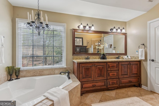 bathroom with double vanity, a garden tub, a sink, and an inviting chandelier