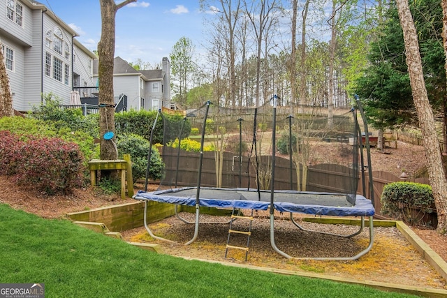 view of yard featuring fence and a trampoline