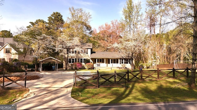 view of property's community with a yard, a detached carport, fence, and a gate