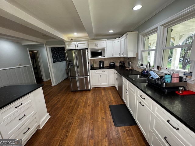 kitchen featuring a sink, dark wood-style flooring, white cabinetry, wainscoting, and stainless steel appliances