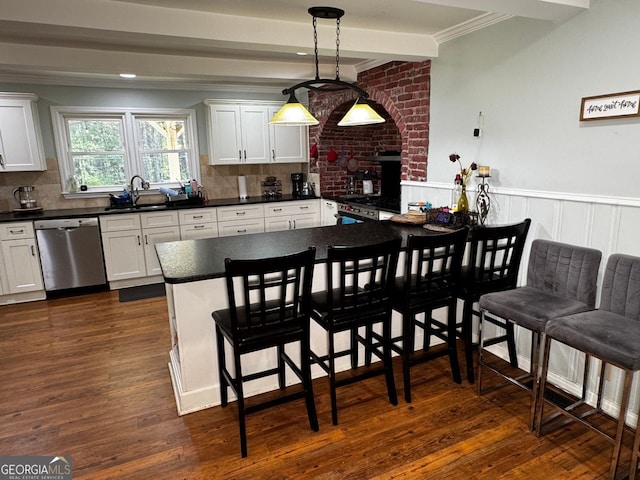 kitchen with stainless steel dishwasher, dark wood-style floors, a sink, and dark countertops