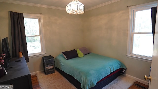 bedroom featuring ornamental molding, a notable chandelier, and multiple windows