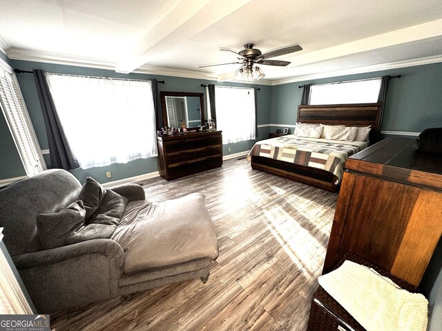 bedroom with crown molding, wood finished floors, ceiling fan, and baseboards