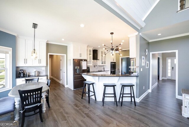 2587 Moons Grove Church Rd, Colbert, GA 30628 - kitchen with stainless steel appliances, wall chimney exhaust hood, a chandelier, decorative backsplash, and healthy amount of natural light
