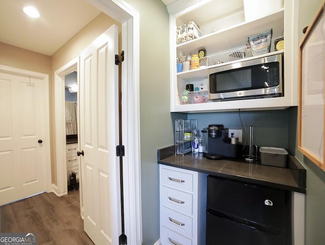 2587 Moons Grove Church Rd, Colbert, GA 30628 - bar area with stainless steel microwave, fridge, and dark wood finished floors