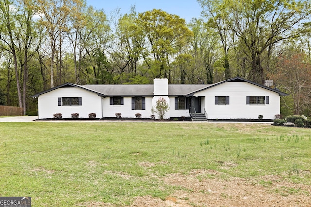 single story home featuring a chimney and a front yard