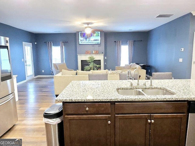 113 Citadel Dr, Hampton, GA 30228 - kitchen featuring open floor plan, dark brown cabinets, plenty of natural light, and light wood-style flooring