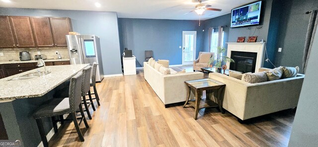 113 Citadel Dr, Hampton, GA 30228 - living area featuring light wood-style flooring, a ceiling fan, a glass covered fireplace, and recessed lighting