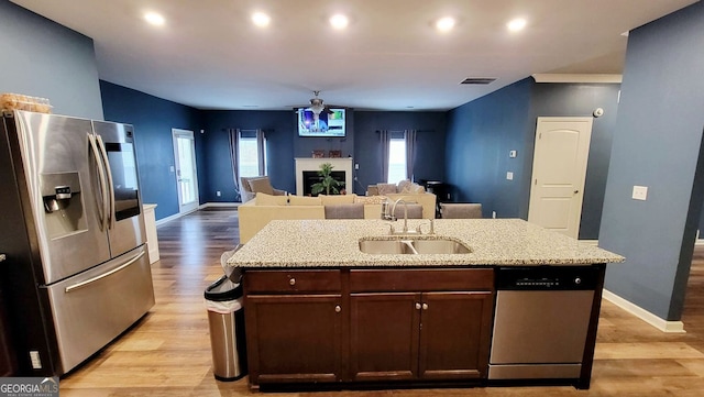 113 Citadel Dr, Hampton, GA 30228 - kitchen featuring appliances with stainless steel finishes, light wood-style flooring, dark brown cabinets, light stone counters, and recessed lighting