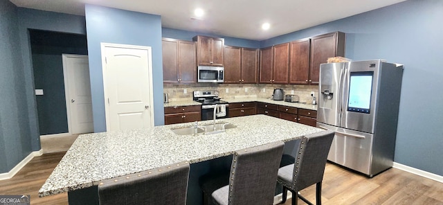 113 Citadel Dr, Hampton, GA 30228 - kitchen with appliances with stainless steel finishes, backsplash, a breakfast bar area, light wood-style flooring, and recessed lighting
