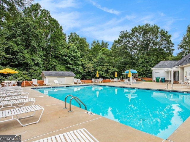 113 Citadel Dr, Hampton, GA 30228 - community pool with a patio area, an outbuilding, and view of wooded area