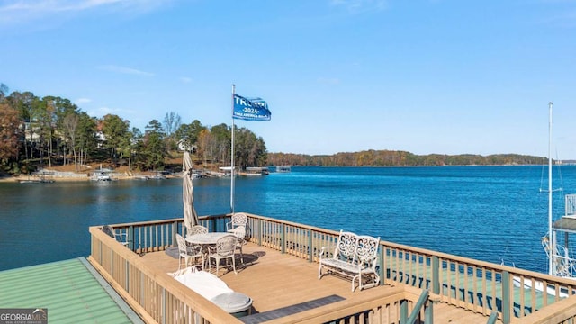dock with outdoor dining space and a deck with water view