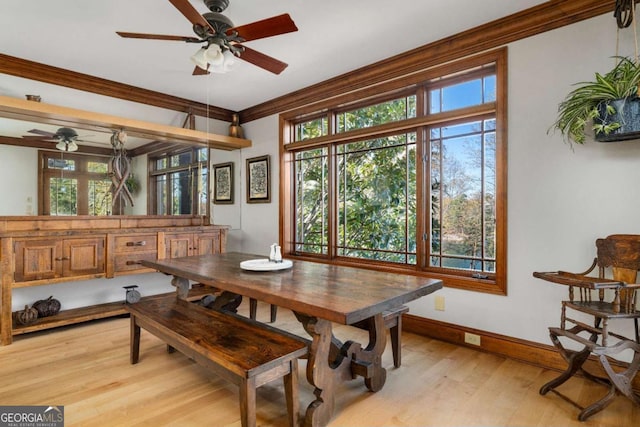 dining area with a ceiling fan, light wood-style floors, ornamental molding, and baseboards