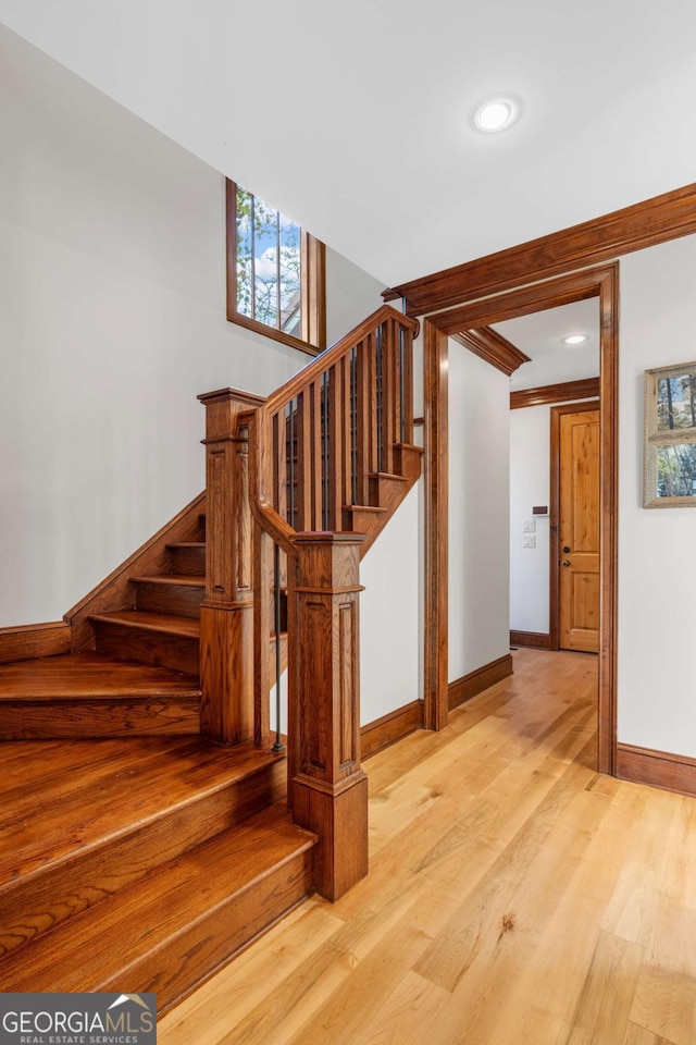 stairs featuring wood finished floors, recessed lighting, and baseboards
