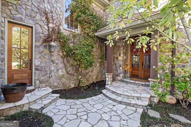 entrance to property featuring stone siding and french doors