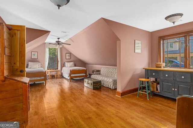 bedroom featuring light wood-style floors, vaulted ceiling, baseboards, and a ceiling fan