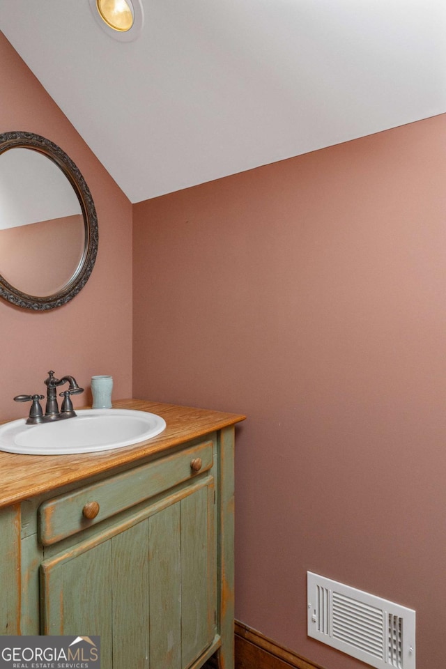 bathroom featuring vanity and lofted ceiling