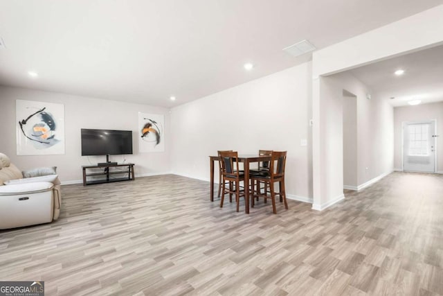 living room featuring light wood-style flooring, baseboards, and recessed lighting