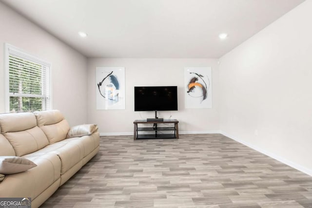 living room featuring recessed lighting, baseboards, and light wood-type flooring