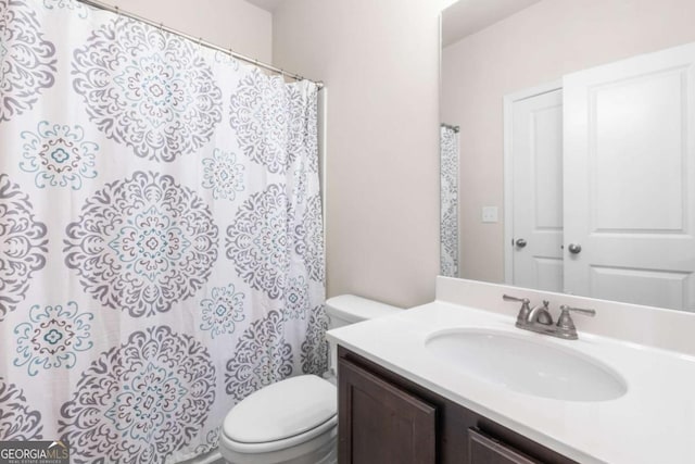 full bathroom with toilet, vanity, and curtained shower