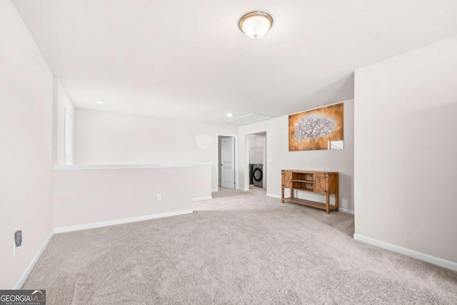 unfurnished living room featuring baseboards, carpet floors, and washer / clothes dryer