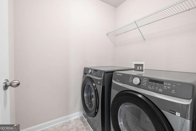 laundry area featuring washing machine and dryer, baseboards, and laundry area