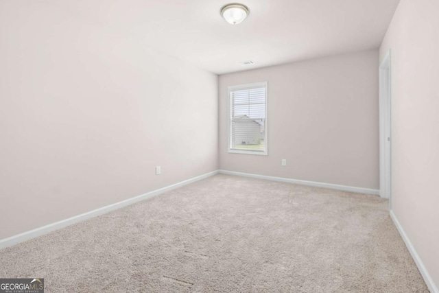 carpeted spare room featuring baseboards
