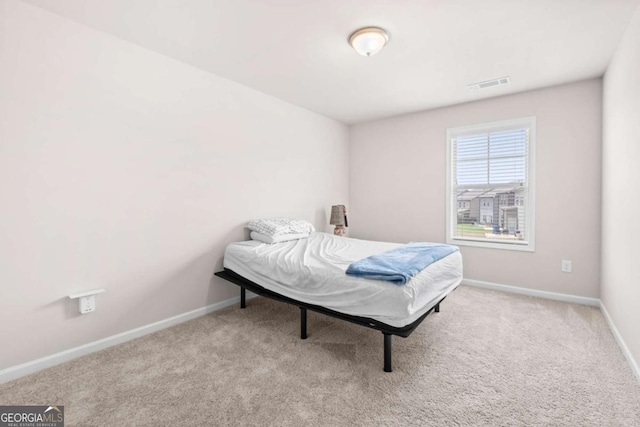 bedroom featuring baseboards, carpet flooring, and visible vents