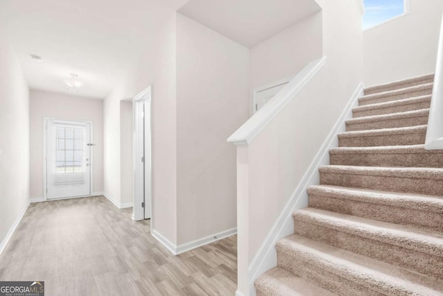 staircase with baseboards and wood finished floors