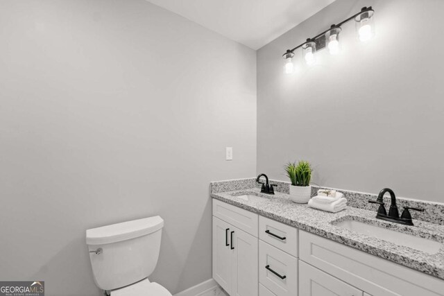 5198 Holly Springs Rd, Pendergrass, GA 30567 - bathroom featuring double vanity, toilet, baseboards, and a sink