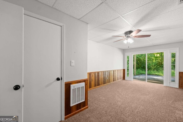 5198 Holly Springs Rd, Pendergrass, GA 30567 - spare room with visible vents, wood walls, a ceiling fan, a drop ceiling, and wainscoting